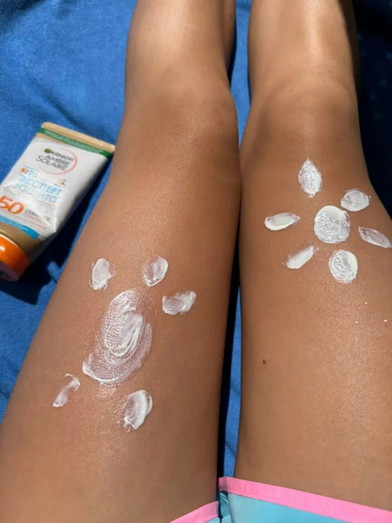 Application de crème solaire sur les jambes (image de banque)
