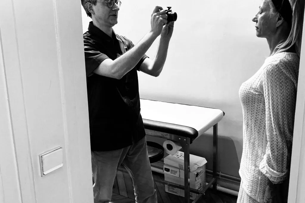 Le Dr Binder réalise les photographies standardisées d une patiente lors de la consultation