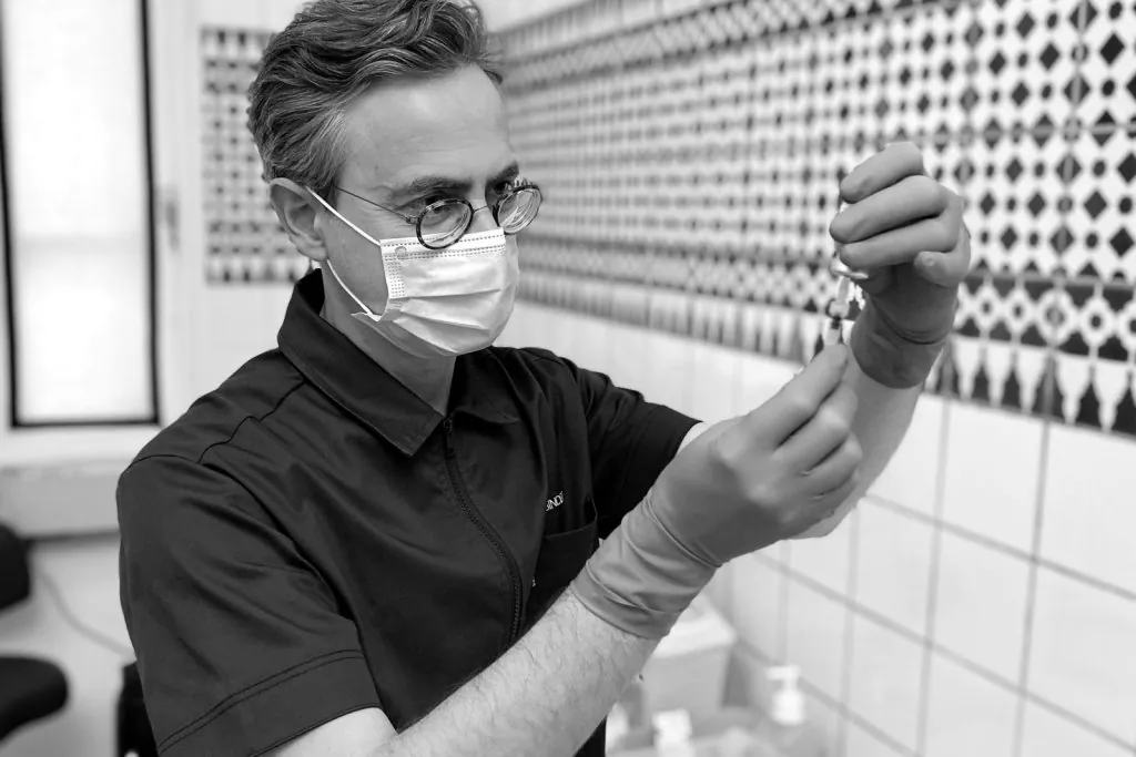 Le Dr Binder prépare une seringue avant une injection de médecine esthétique