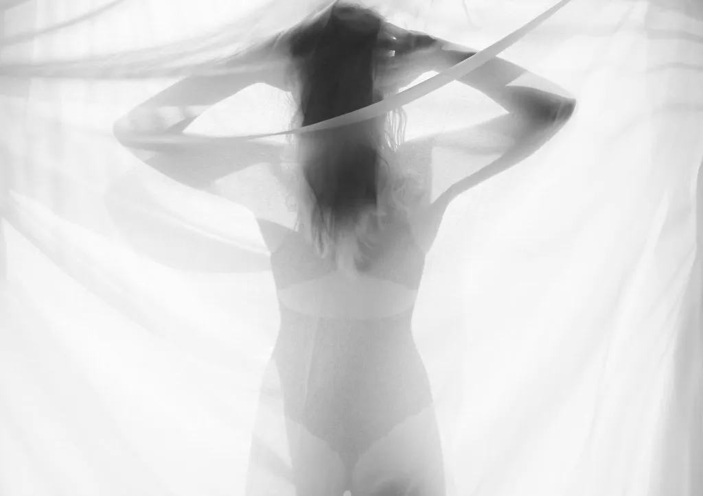 Silhouette de femme derrière un voile (image de banque)